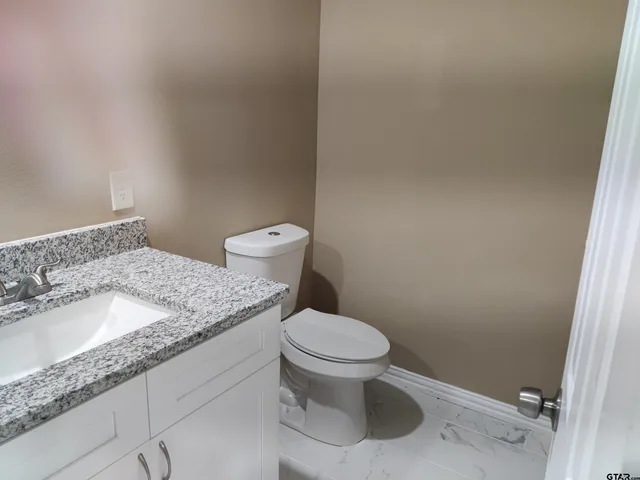 a white toilet sitting next to a bathroom sink