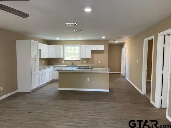 a large kitchen with kitchen island a sink stainless steel appliances and cabinets