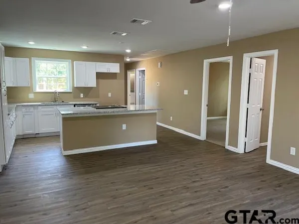 a view of kitchen with granite countertop window and wooden floor
