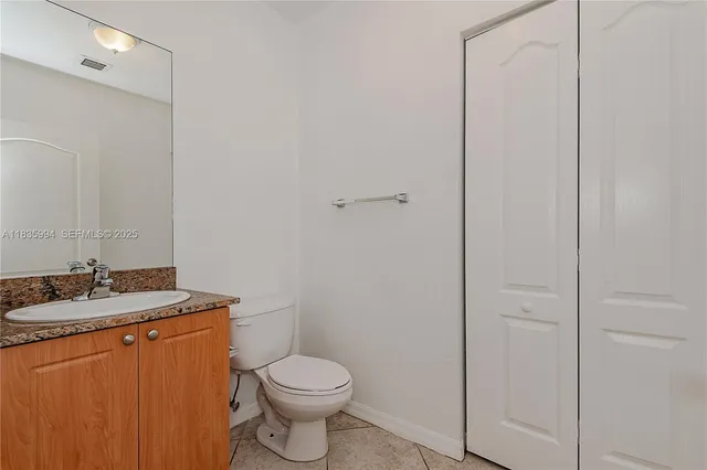 a bathroom with a granite countertop toilet and sink
