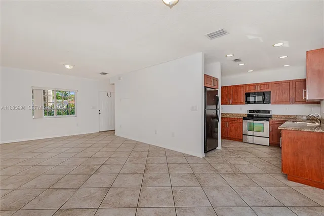 a kitchen with stainless steel appliances granite countertop a refrigerator and a sink