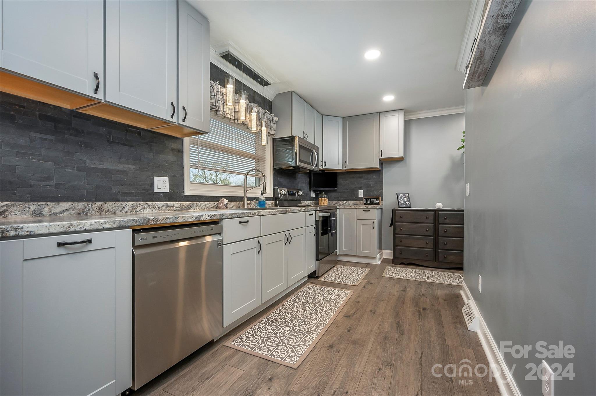 207 Smith Grove Road Forest City, NC 28043 - Photo 9 of 37 a kitchen with kitchen island granite countertop wooden cabinets and white appliances