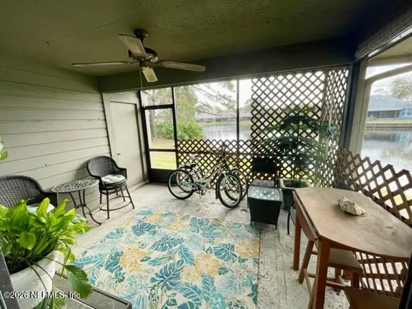a table with chairs and a vase of flowers sitting on a table