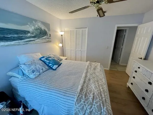 a bedroom with a bed and a flat tv screen on dresser
