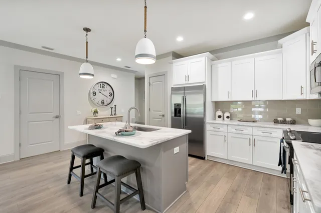 a kitchen with kitchen island granite countertop a sink a counter space stainless steel appliances and cabinets