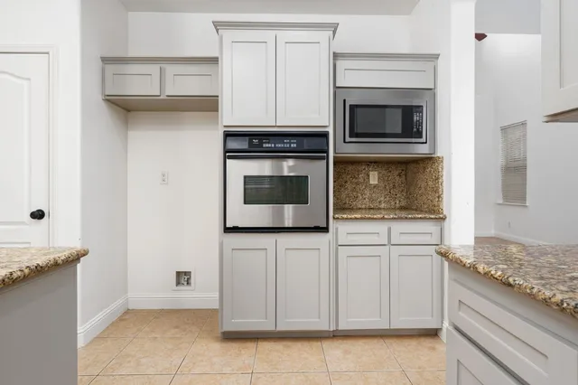 a large kitchen with cabinets and stainless steel appliances