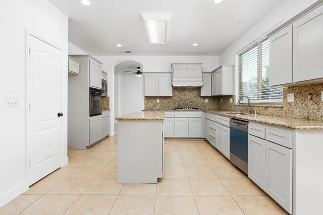 a kitchen with a refrigerator a sink and cabinets