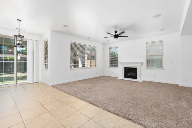 an empty room with windows and fireplace
