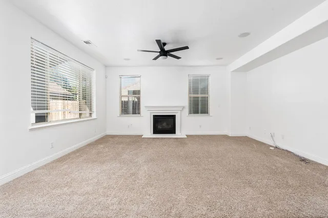 a view of empty room with fireplace and windows