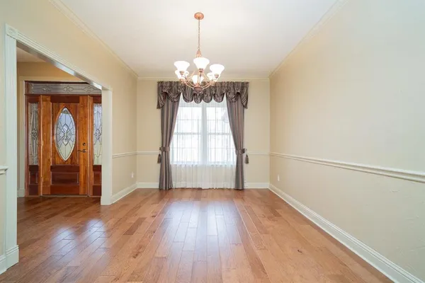 a view of a room with wooden floor chandelier and a window