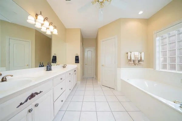 a spacious bathroom with a bathtub sink and mirror