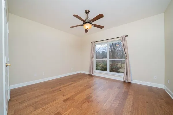 an empty room with wooden floor and windows