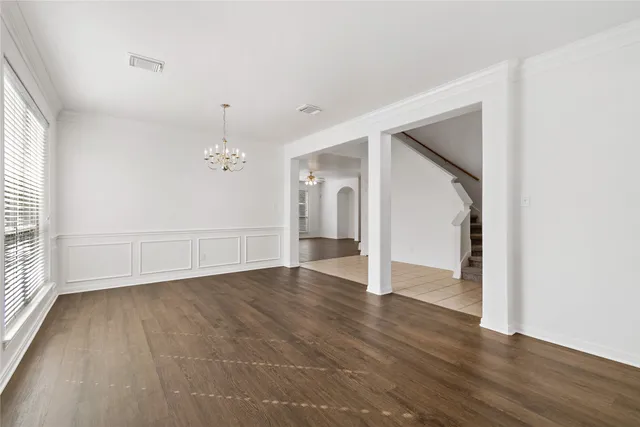 a view of an empty room with wooden floor and a fireplace