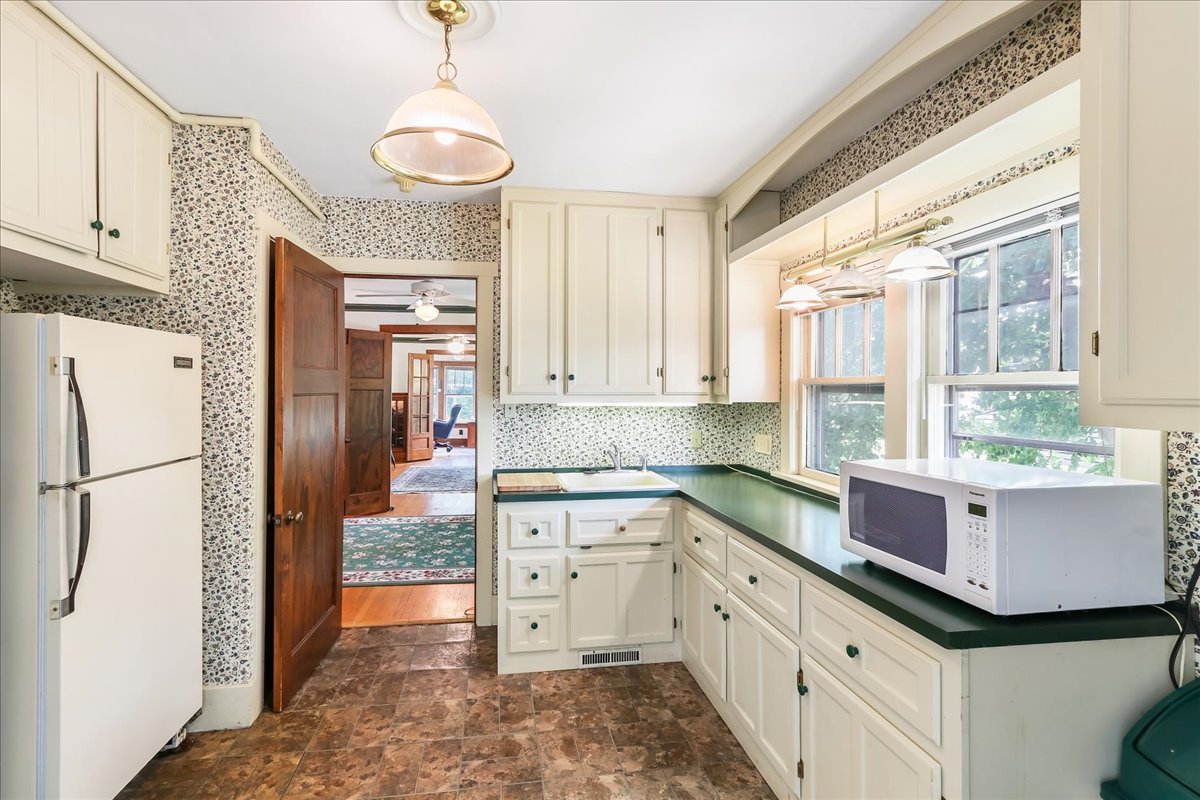 124 Harrison Street Barrington, IL 60010 - Photo 17 of 33 a kitchen with granite countertop a refrigerator a sink a stove and white cabinets