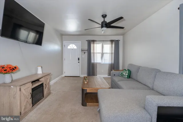 a living room with a couch a window and a flat screen tv