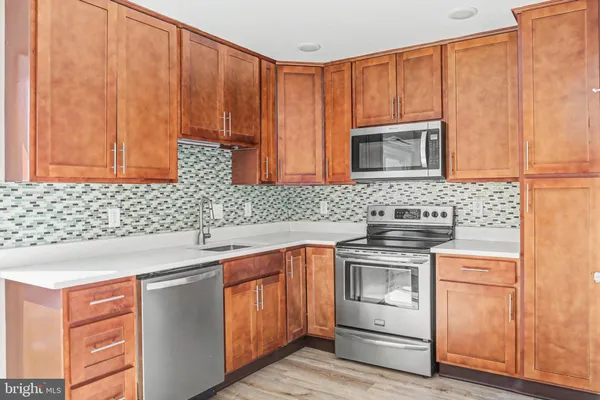 a kitchen with stainless steel appliances granite countertop wooden cabinets a sink and dishwasher