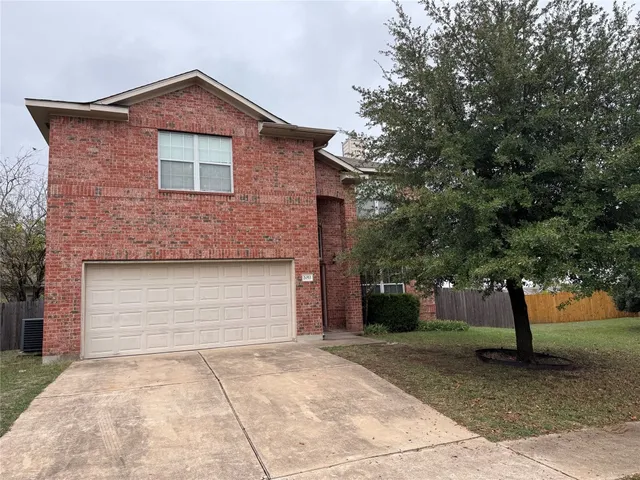 a front view of a house with a yard and trees