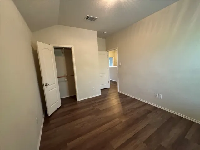 an empty room with wooden floor and entrance