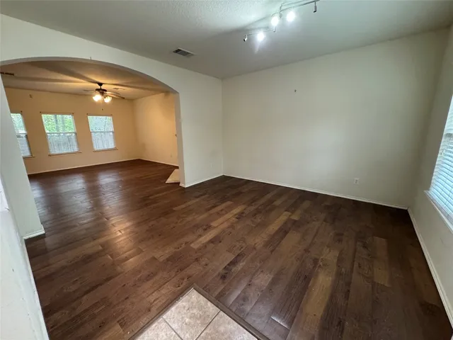 an empty room with wooden floor and windows