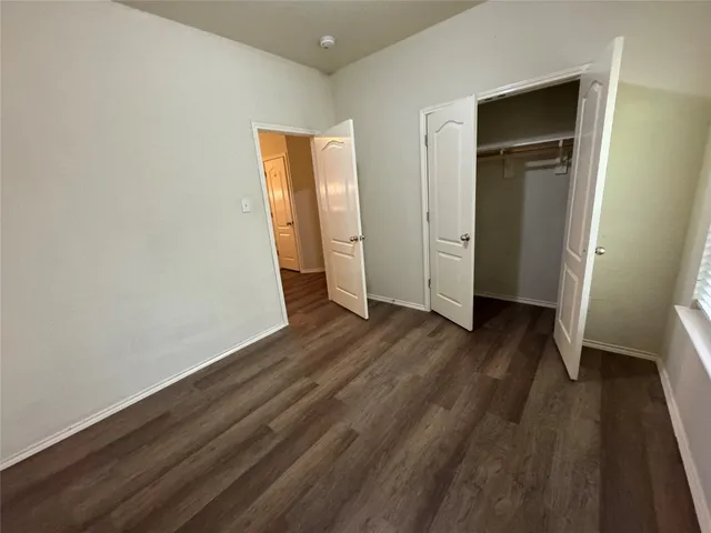 an empty room with wooden floor and closet