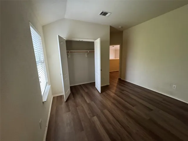 an empty room with wooden floor and closet