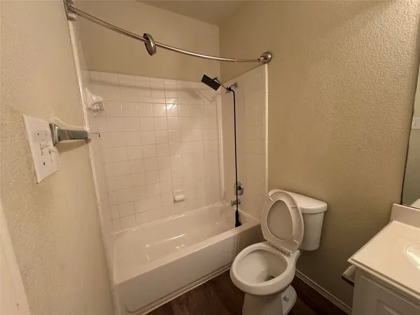 a white toilet sitting next to a bath tub and a shower