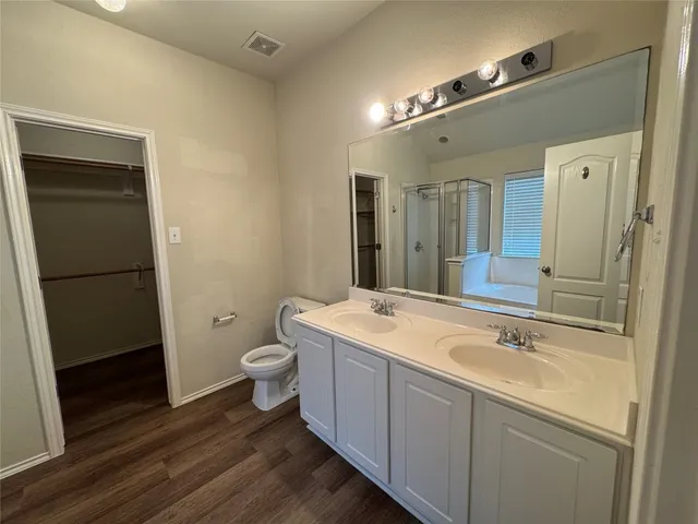 a spacious bathroom with a double vanity sink toilet and shower