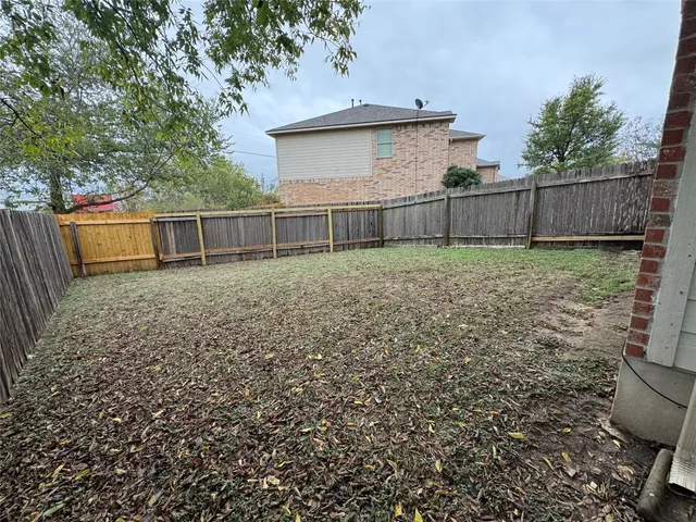a view of a backyard with wooden fence