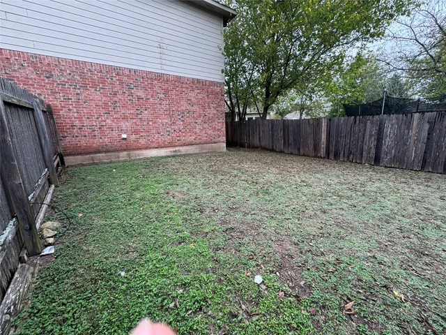 a view of garden with wooden fence