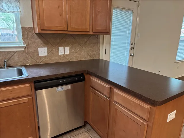 a kitchen with granite countertop cabinets stainless steel appliances and a sink