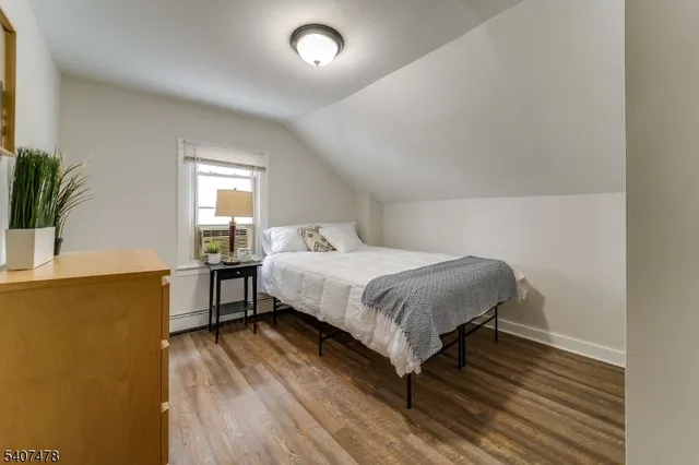 a bedroom with a bed and a potted plant on table