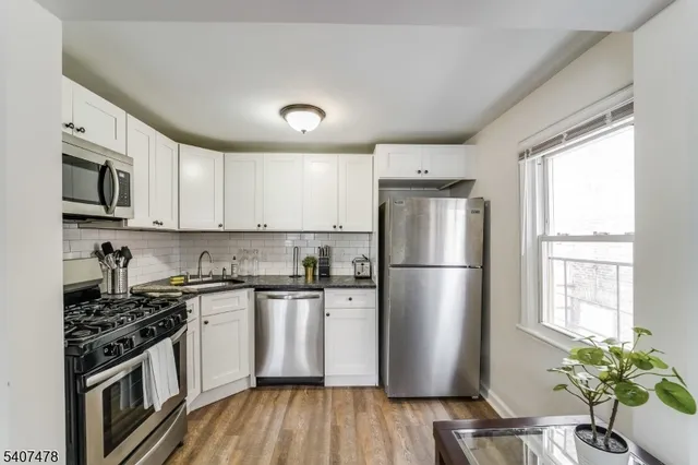 a kitchen with a refrigerator a sink a stove a microwave and cabinets