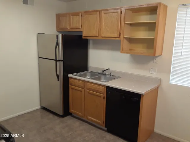 a kitchen with a sink cabinets and refrigerator