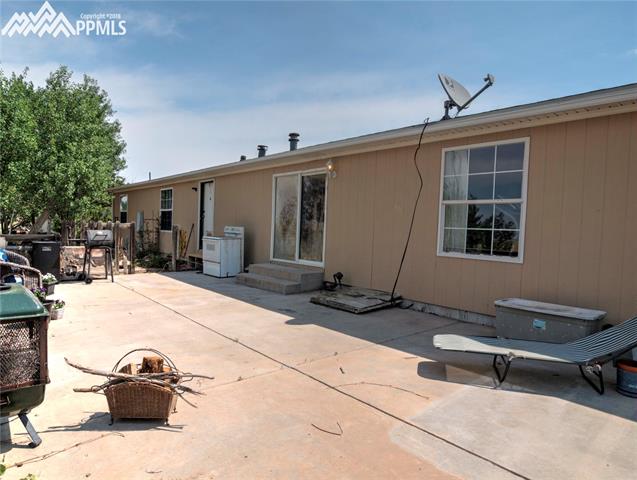 890 Ranchette Place Calhan, CO 80808 - Photo 23 of 26 The back of the home with a large concrete patio that is on the west side. There's amazing views of Pikes Peak from this patio.