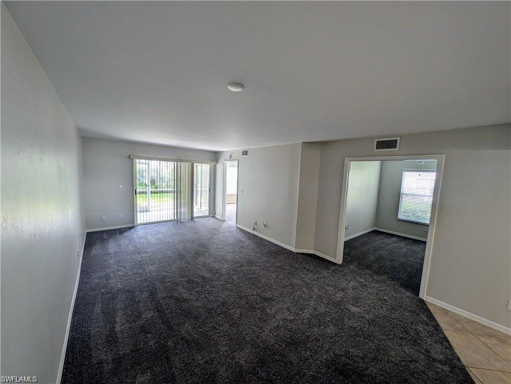 1915 Courtyard Way, Unit G102 Naples, FL 34112 - Photo 4 of 16 Empty room with healthy amount of natural light and light carpet