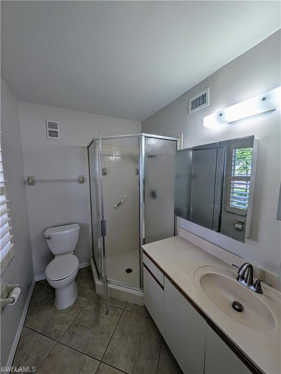 1915 Courtyard Way, Unit G102 Naples, FL 34112 - Photo 6 of 16 a bathroom with a toilet sink and mirror