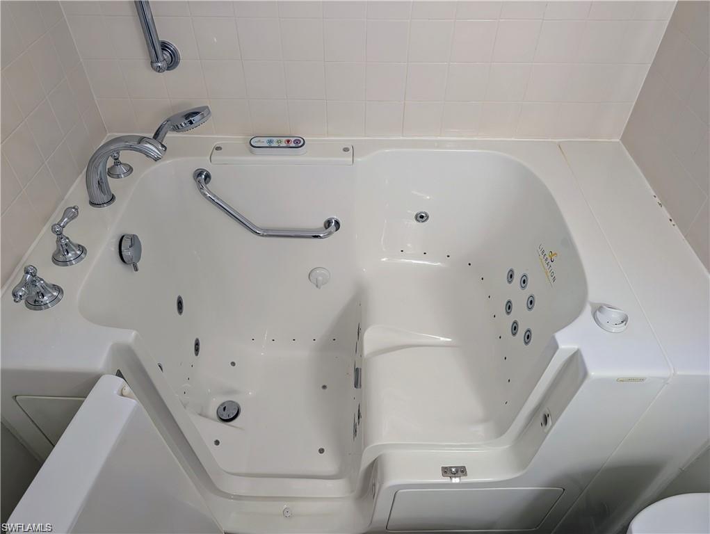 1915 Courtyard Way, Unit G102 Naples, FL 34112 - Photo 9 of 16 a bathroom with a bathtub and a shower
