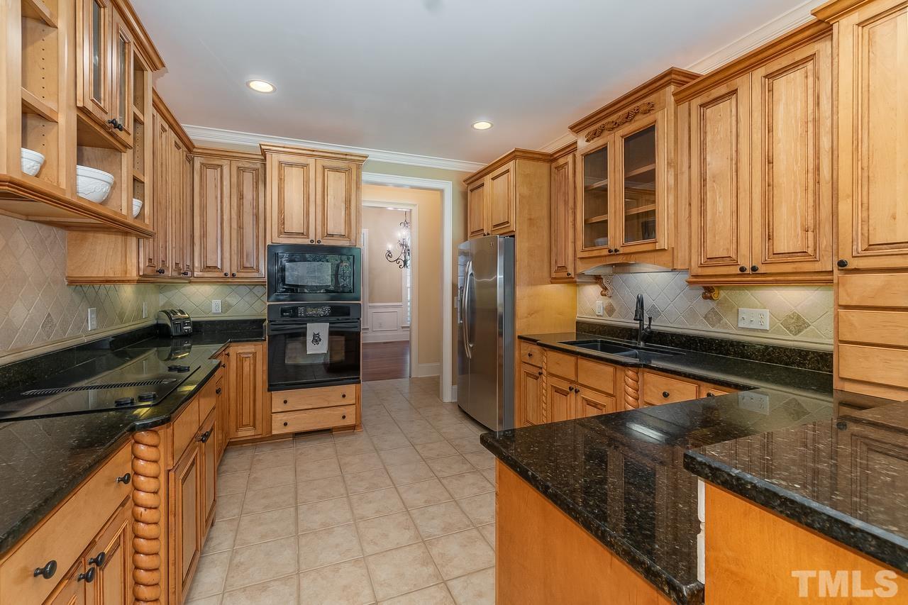 1313 Wynncrest Court Raleigh, NC 27603 - Photo 8 of 30 a kitchen with stainless steel appliances granite countertop a refrigerator a stove and a sink with wooden cabinets
