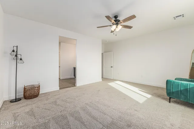 a view of a livingroom with a ceiling fan and carpet