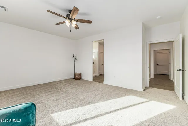 a view of a livingroom with a ceiling fan and carpet