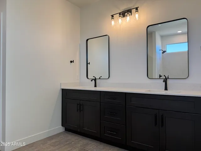 a bathroom with double vanity sinks and a mirror