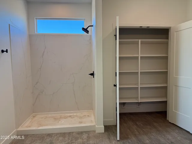 a view of walk in closet with empty racks