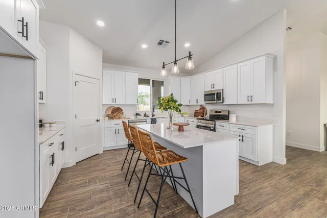 a kitchen with white cabinets and stainless steel appliances