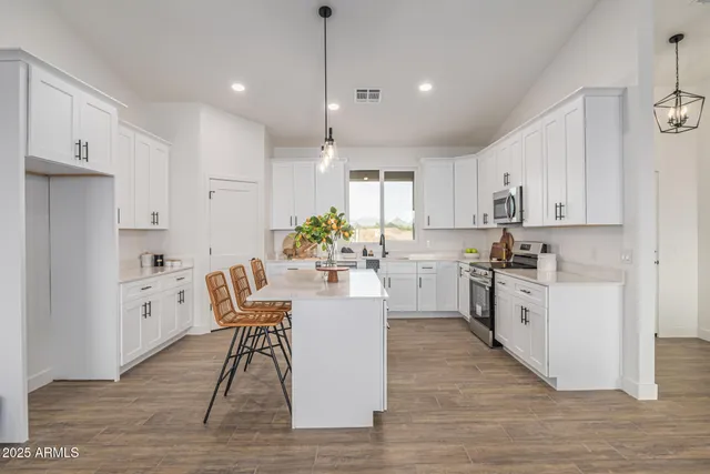 a kitchen with white cabinets and sink