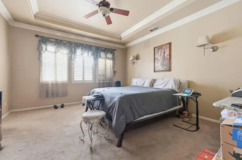 a spacious bedroom with a bed and a chandelier