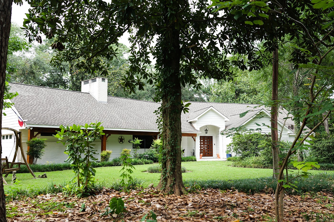 a view of house with a yard and potted plants