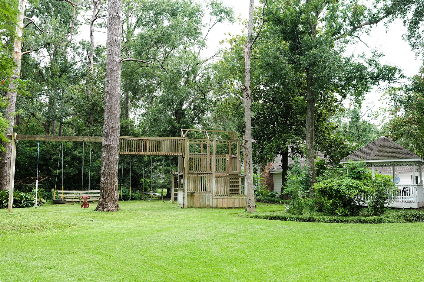 9818 Shadow Wood Drive Houston, TX 77080 - Photo 25 of 36 a backyard of a house with plants and large trees