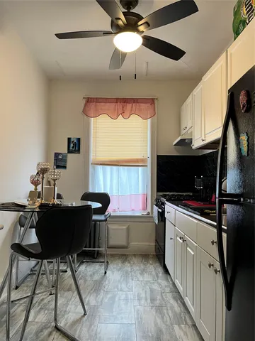 a kitchen with a stove a flat screen tv and a window