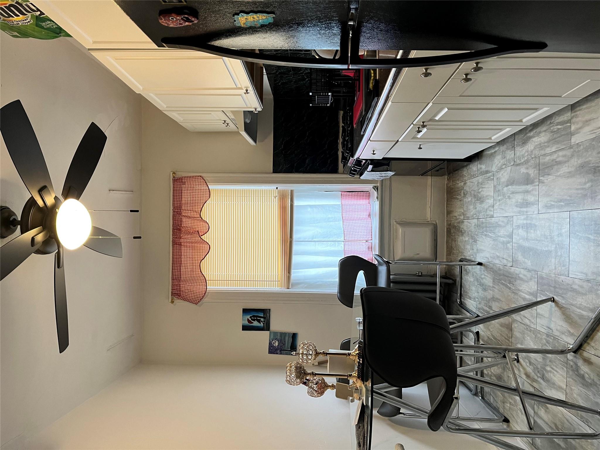 39-82 65th Place, Unit 4F Queens, NY 11377 - Photo 6 of 10 a kitchen with a stove a flat screen tv and a window