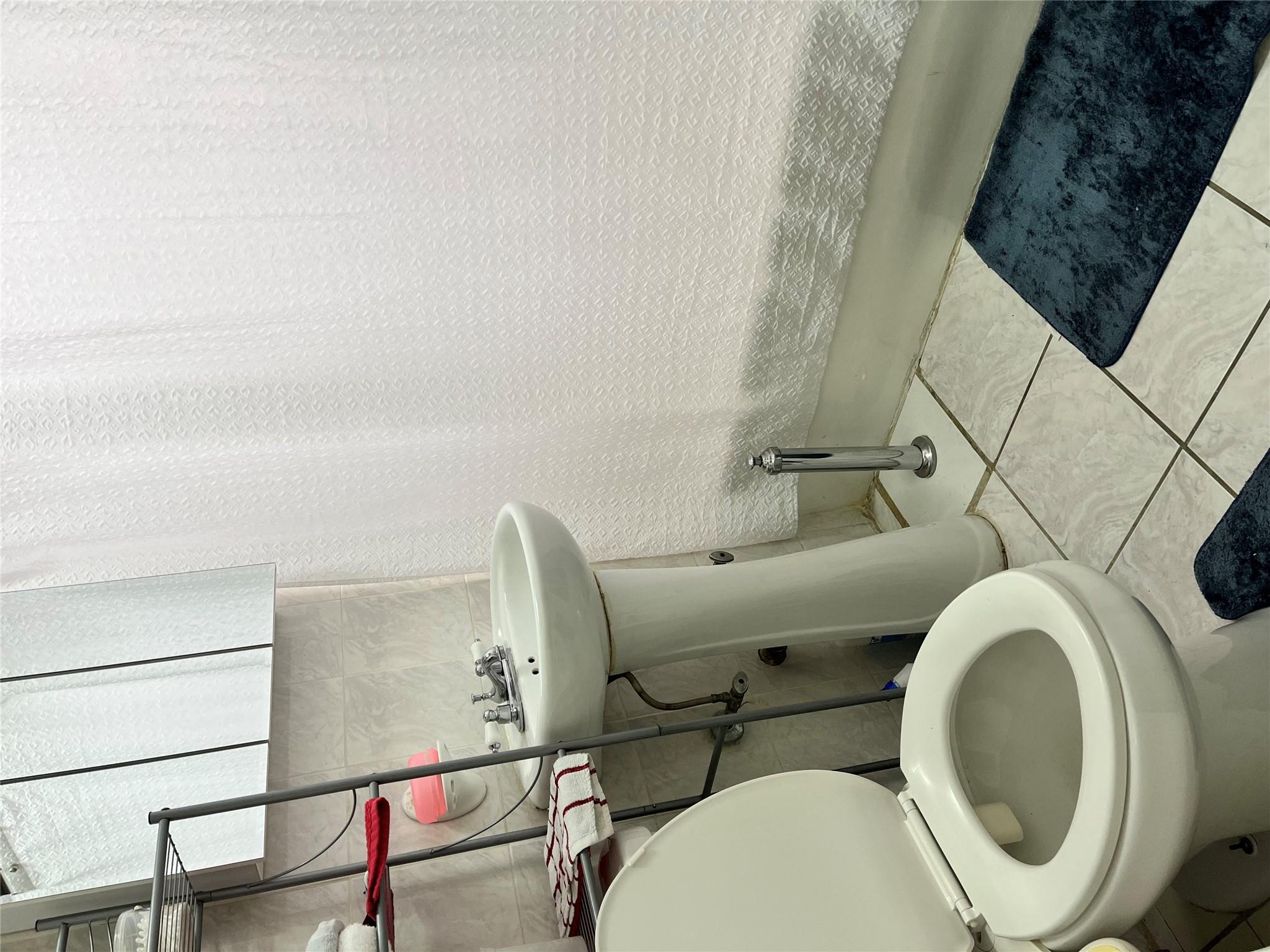 39-82 65th Place, Unit 4F Queens, NY 11377 - Photo 7 of 10 a bathroom with a sink and a toilet